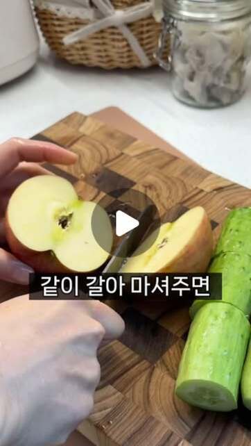 도마 위에서 사과를 반으로 자르고 옆에는 오이가 놓여 있다. 화면 중앙에 '같이 갈아 마셔주면'이라는 자막이 있다.