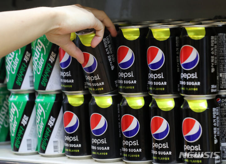 한 사람이 진열대에서 펩시 제로 슈가 캔을 집으려 하고 있으며, 옆에는 칠성사이다 캔이 함께 진열되어 있다.