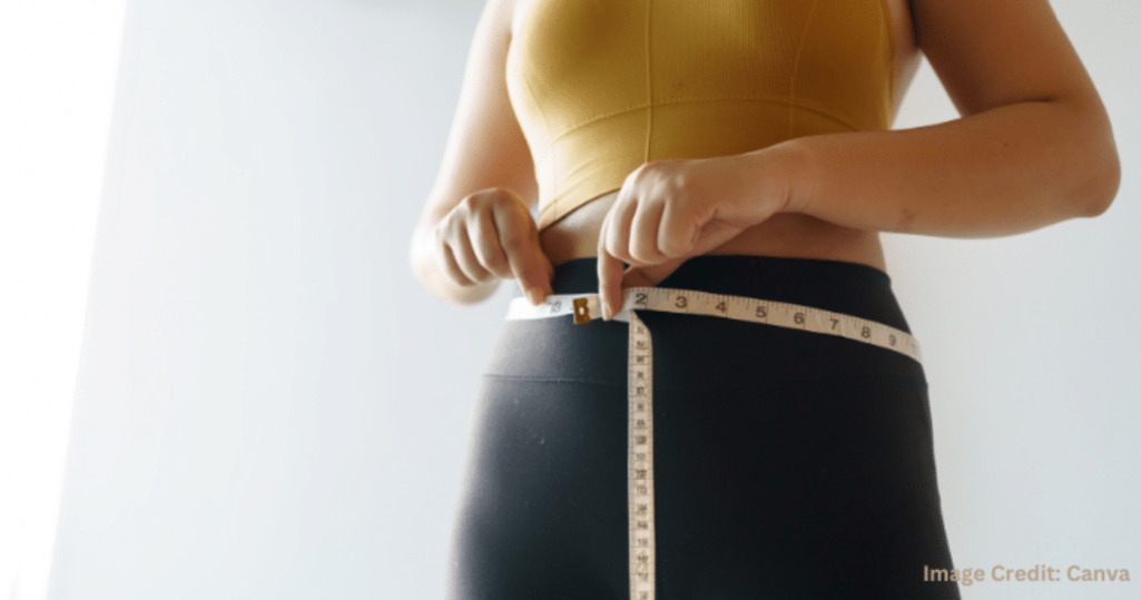 운동복을 입은 사람이 허리둘레를 줄자로 재고 있는 모습