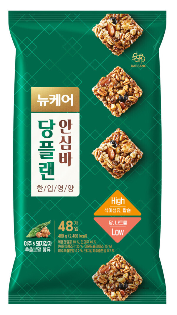 녹색 바탕에 곡물바 이미지가 네 개 배열되어 있는 뉴케어 당플랜 안심바 포장지. 'High 식이섬유, 칼슘', 'Low 당, 나트륨' 문구와 48개입, 여주와 돼지감자 추출분말 함유 강조.