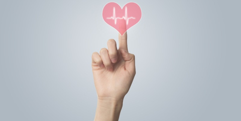 한 손가락이 하트 모양과 심장 박동 그래프 이미지를 가리키고 있다.