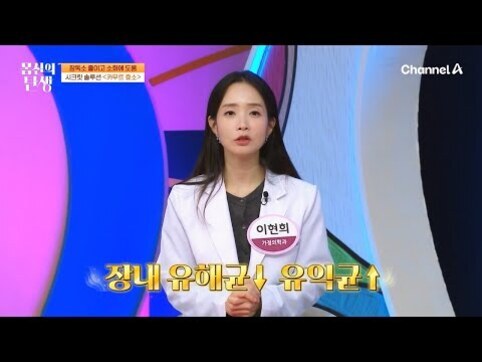 흰 가운을 입은 여성이 TV 프로그램 세트장에서 손을 모으고 서 있으며, 자막에는 '장내 유해균↓ 유익균↑'이 표시되어 있다.