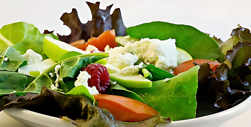 신선한 채소와 토마토, 치즈, 라즈베리 등이 담긴 샐러드 접시